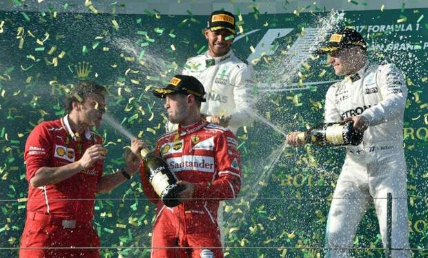 Racing driver spraying a magnum of champagne from the winner's podium