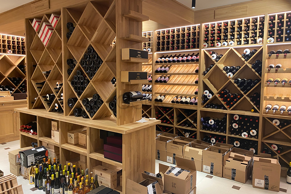 Rows of dusty red wine bottles aging in a dimly lit private wine cellar