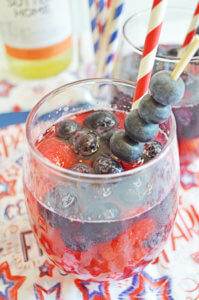 Red white and berry sangria with blueberry skewer garnish.