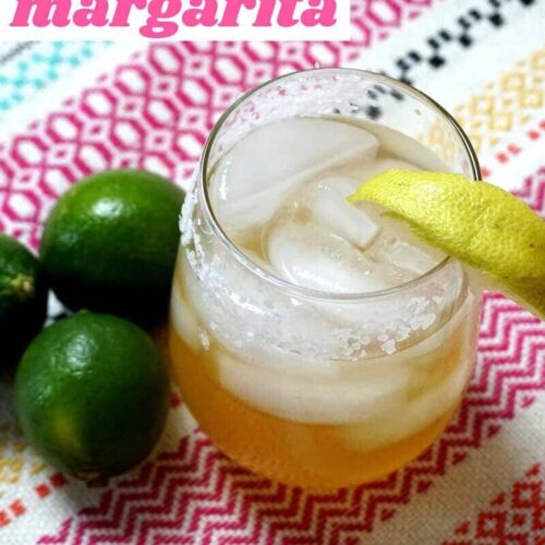Low Carb, skinny margarita made with Baja Bob's Original Margarita Mix. Shown on a vibrant striped placemat with key limes.