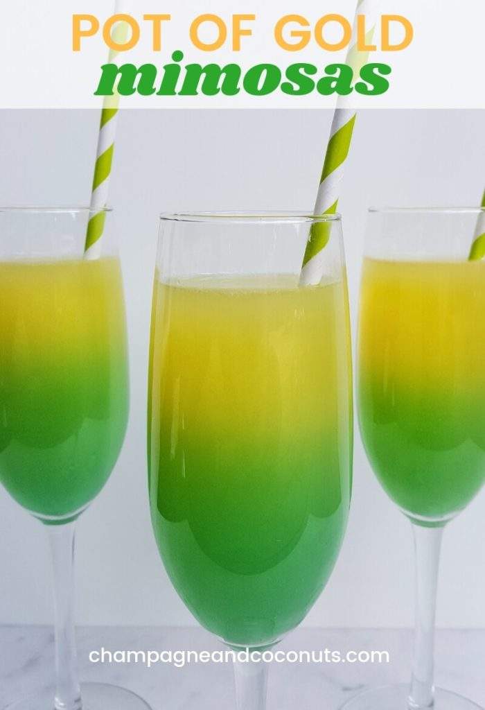 Pot of Gold Mimosas Recipe made with champagne, blue curacao, orange juice and vodka. The yellow and green cocktail is served in a champagne flute with a paper straw.