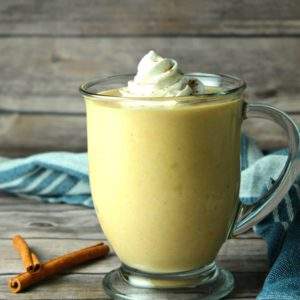 A mug of Slow Cooker Pumpkin White Hot Chocolate topped with whipped cream.
