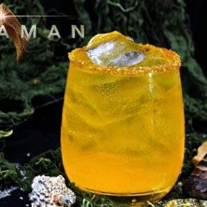 A golden cocktail surrounded by seashells. Text: Aquaman.