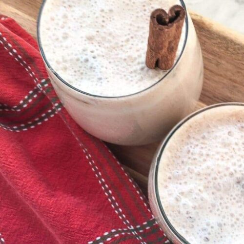 Two glasses of healthier horchata on a wood tray with a red plaid napkin.