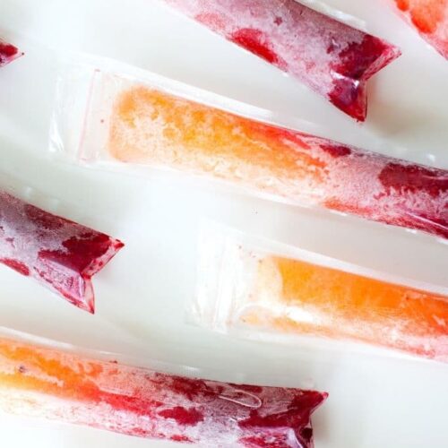 Several red and orange popsicles on a tray.