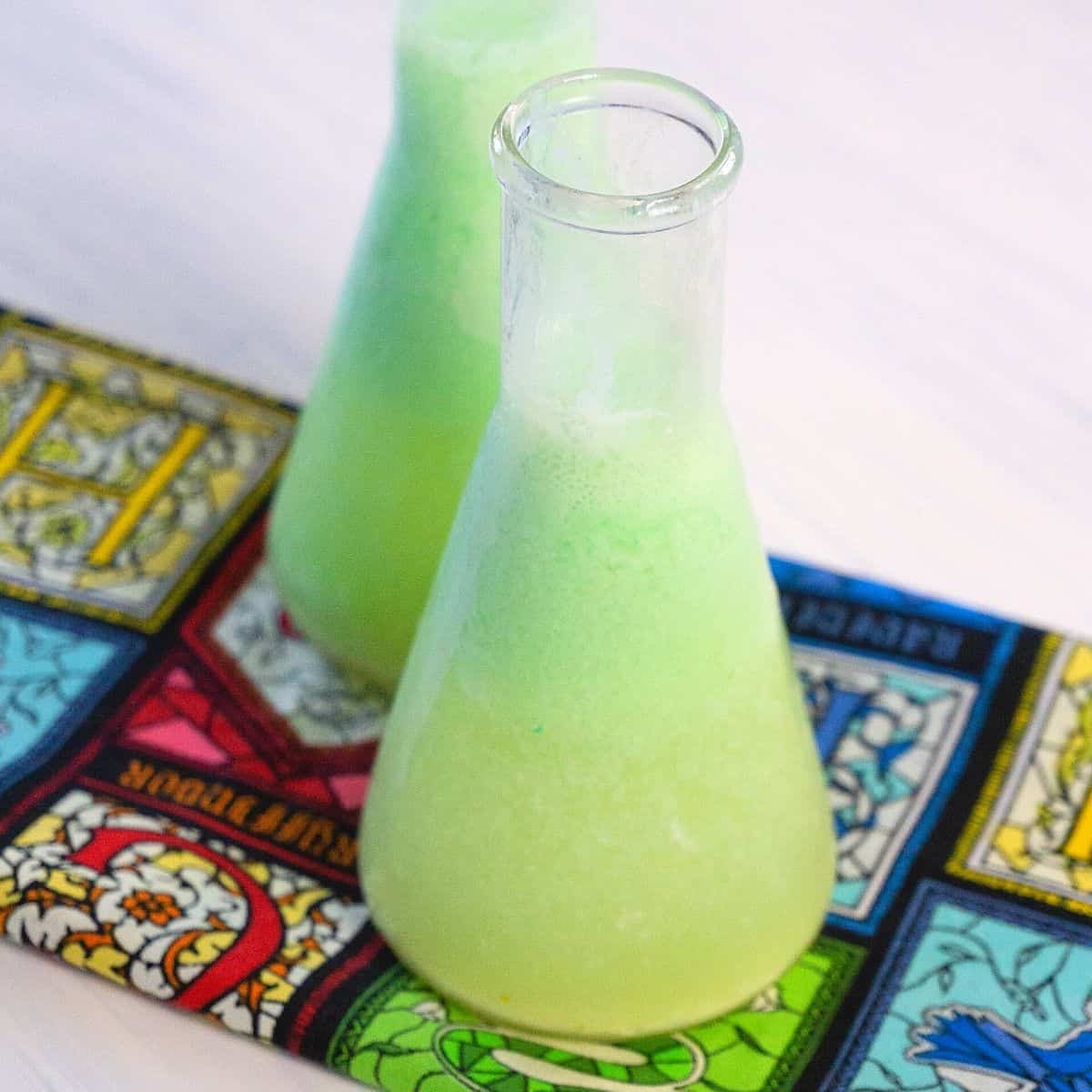 A Harry Potter napkin with two emerald potion filled beakers.