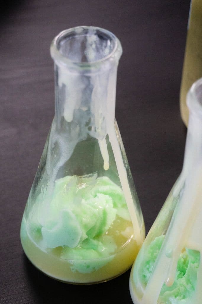 In process shot of adding lime sherbet to a beaker to make Emerald Potion.