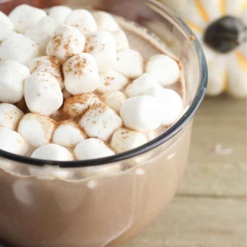 A three quarters shot of a mug of hot chocolate topped with lots of marshmallows.