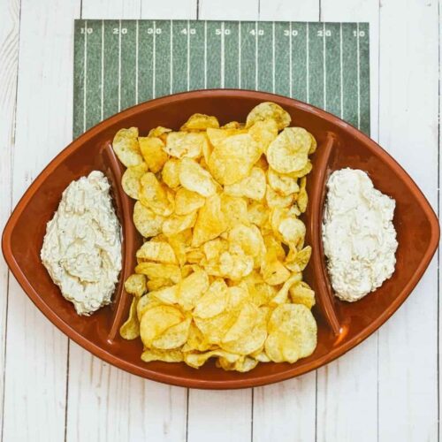 A football shaped bowl with chips and 2 sections for French onion dip.