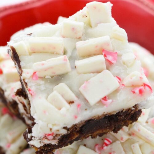 A close up of a brownie with white chocolate peppermint ganache on a red plate.