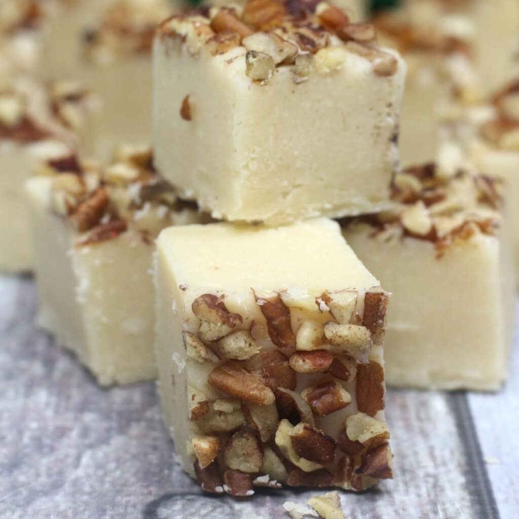 A stack of fudge squares topped with chopped pecans.