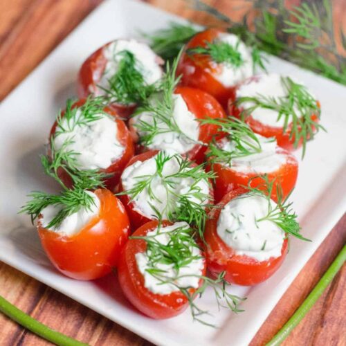 Cherry tomatoes stuffed with cream cheese garnished with fresh dill.